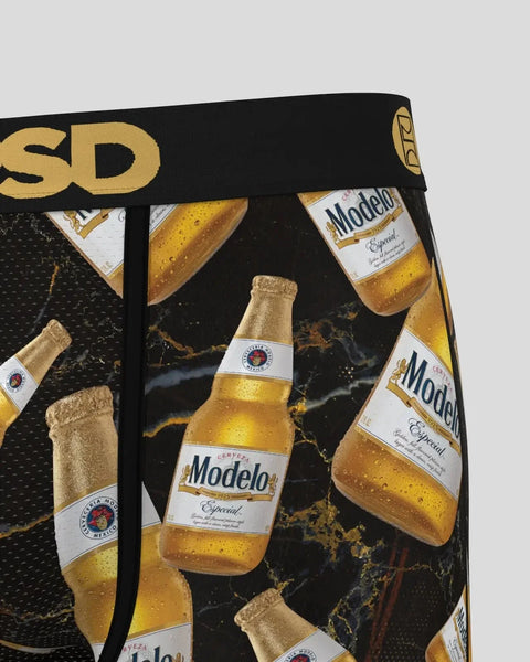 Modelo Especial beer bottles with condensation on black and gold marble background fabric with gold waistband text.