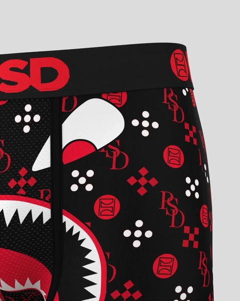 Black boxer briefs with red and white gaming-themed print including controller buttons, geometric patterns, and logo text.