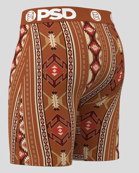 PSD boxer briefs with brown waistband featuring geometric Aztec-inspired pattern in red, cream, and tan stripes.