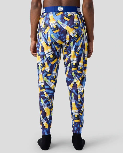 Men's lounge pants with repeated Corona Extra beer bottle and lime print on blue background.