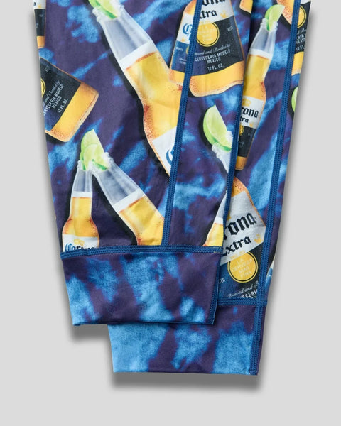 Blue tie-dye patterned lounge pants with Corona Extra beer bottle and lime print throughout.