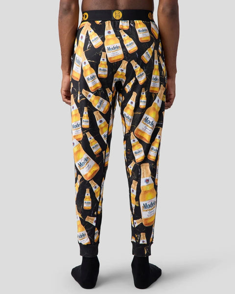 Black lounge pants with repeating Modelo beer bottle print and yellow elastic waistband.