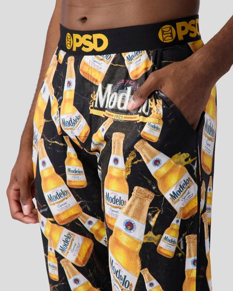 Men's black shorts with repeated Modelo beer bottle print and PSD waistband.