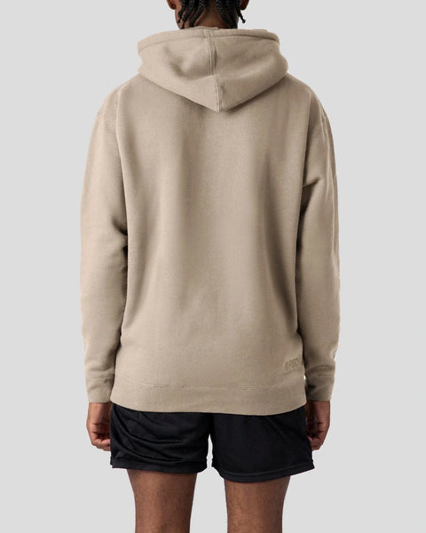 Beige pullover hoodie with drawstring hood shown from back view on model wearing black shorts.