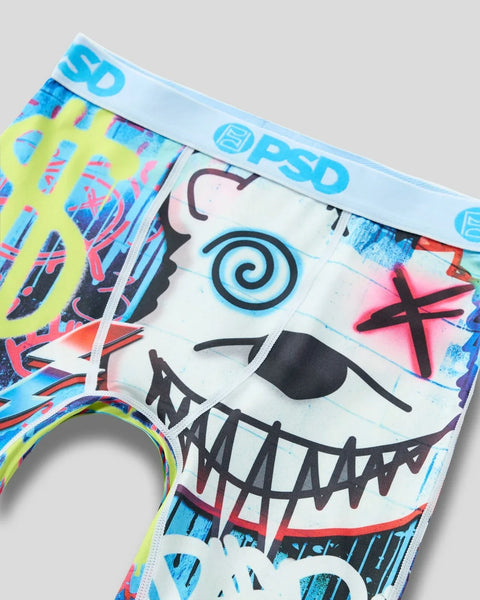 Colorful men's underwear featuring cartoon bear face with spiral eye, stitched smile, and neon graffiti-style patterns in yel