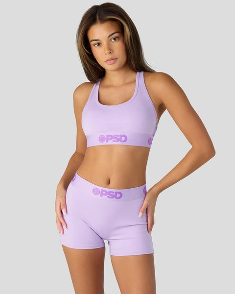 Woman wearing lavender sports bra and shorts set with PSD branding.