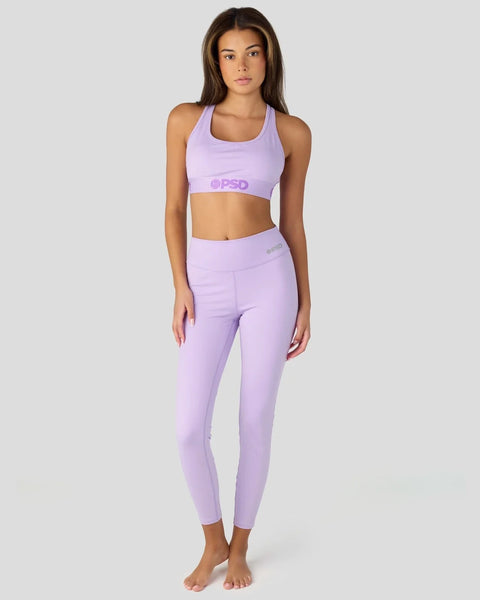 Woman wearing lavender sports bra and matching cropped leggings with PSD branding.