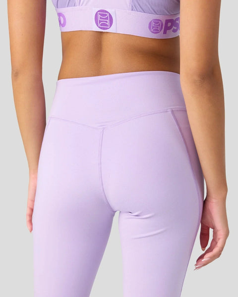 Lavender high-waisted leggings with matching sports bra featuring purple logo band, shown on model from waist down.