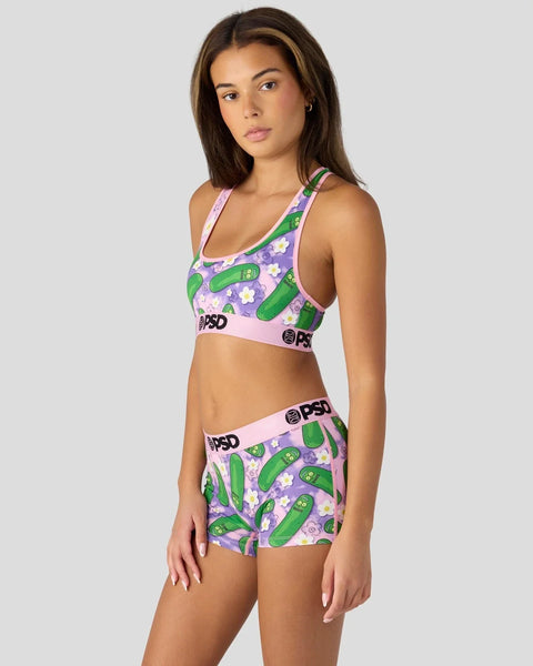 Women's sports bra and shorts set with green pickle and purple flower pattern on pink background.