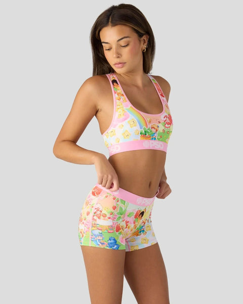 Woman wearing pink sports bra and matching shorts with colorful character print design.