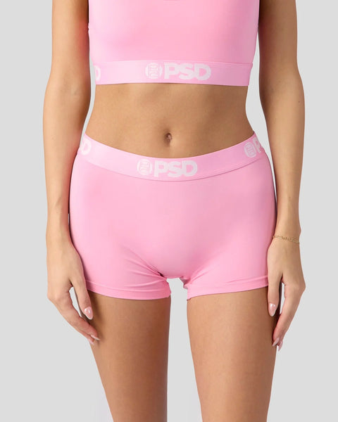 Pink sports bra and shorts set with branded elastic waistband shown on model.