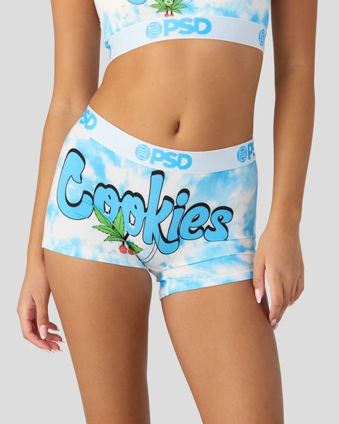 Blue tie-dye shorts with "Cookies" text, cannabis leaf graphics, and white PSD waistband.