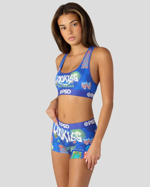 Blue sports bra and shorts set with Cookies branding and colorful graphic print throughout.