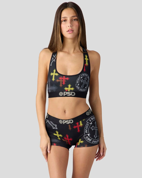 Black sports bra and shorts set with yellow and red cross prints and PSD branding.