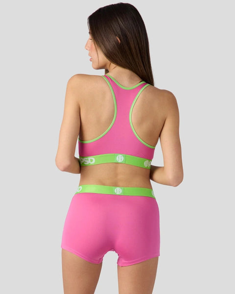 Pink sports bra and shorts set with lime green trim and waistband details, shown from back view.