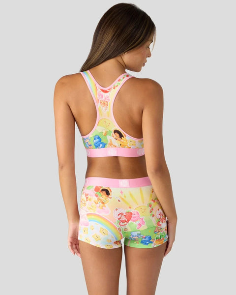 Pink racerback sports bra and matching shorts with Strawberry Shortcake and Care Bears characters and rainbow print.