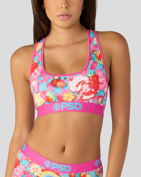 Pink and turquoise sports bra with colorful floral and character print, featuring PSD branding on elastic band.