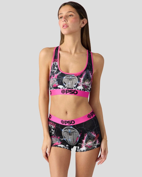 Woman wearing black and pink PSD sports bra and shorts set with chainsaw graphic print.