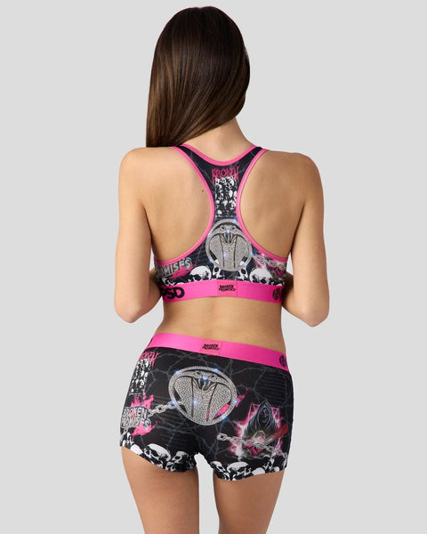 Women's sports bra and shorts set with black and white chainsaw graphic design and neon pink trim.