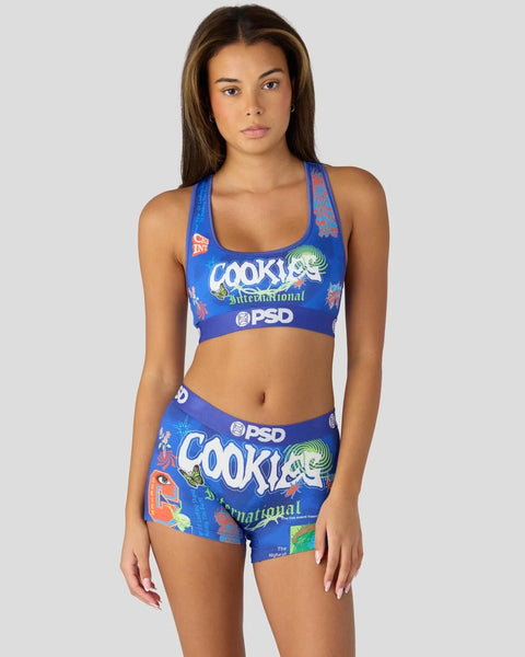 Blue racerback sports bra and matching shorts set with "Cookies International" and PSD branding.