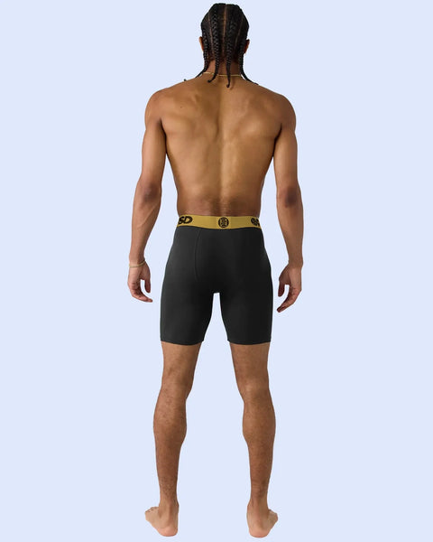 Black shorts with gold waistband and logo, shown on model from back view.