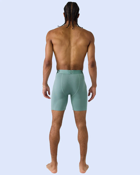 Man wearing sage green modal boxer briefs with elastic waistband, shown from behind.