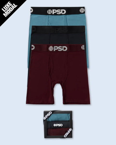 Three modal briefs in blue, black, and burgundy with PSD branded waistbands, displayed flat and in packaging.