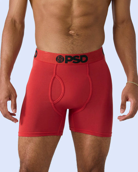 Red boxer briefs with black waistband logo and contoured pouch on model.