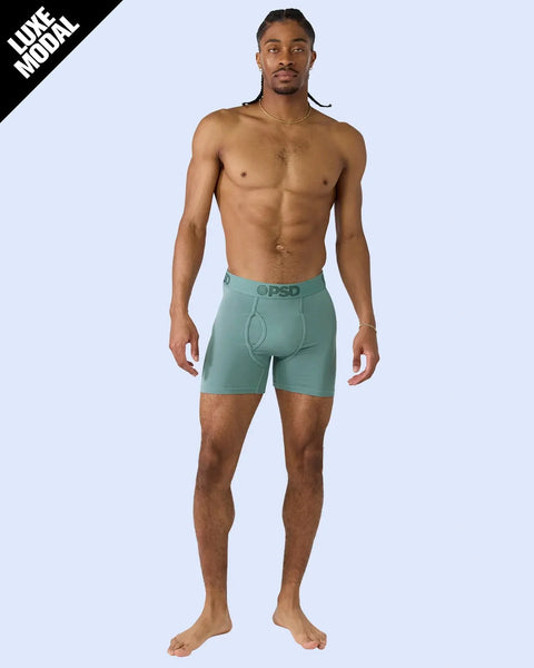 Man wearing sage green modal boxer shorts with branded waistband.