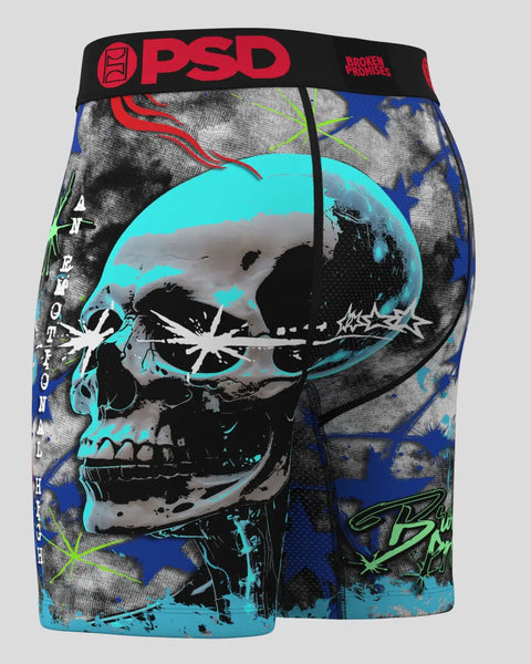 PSD boxer briefs with black waistband featuring cyan and black skull graphic, blue stars, and red text on gray base.