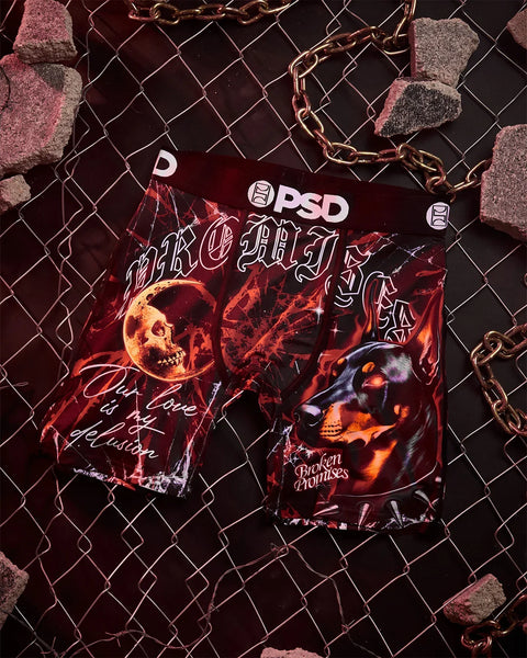 Dark red graphic t-shirt with skull imagery and chain detail displayed on chain-link fence background.
