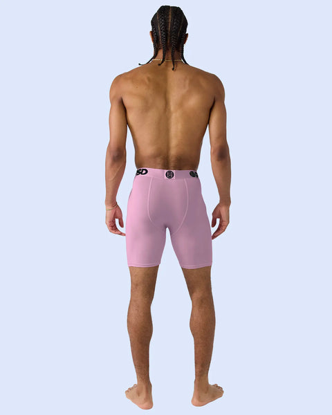 Man wearing pink modal boxer briefs with black waistband buttons, back view.