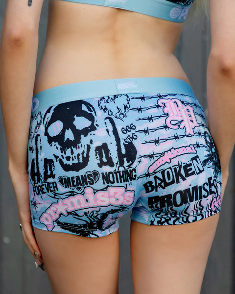 Light blue shorts with black skull graphic, barbed wire, and pink text reading 