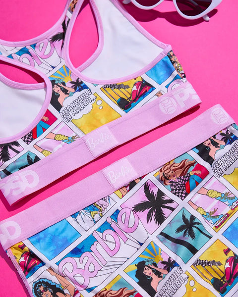 Barbie Malibu two-piece swimsuit with comic-style print, pink trim, and matching sunglasses on pink background.