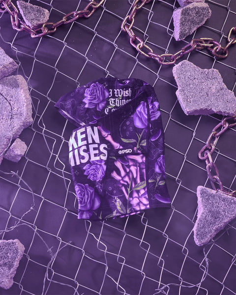 Purple graphic tee with rose floral print and text design, displayed flat on purple mesh background with decorative chain and