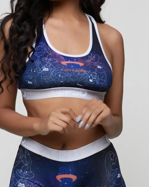 Navy sports bra with white trim and Space Jam character outlines printed throughout.