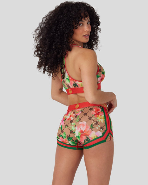 Two-piece swimsuit with floral print featuring pink and red flowers on tan background, red trim and straps.