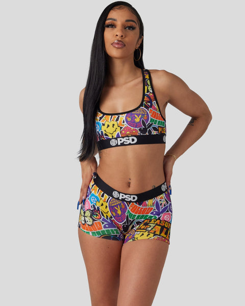 Woman wearing colorful comic-print sports bra and matching shorts with black PSD waistbands.