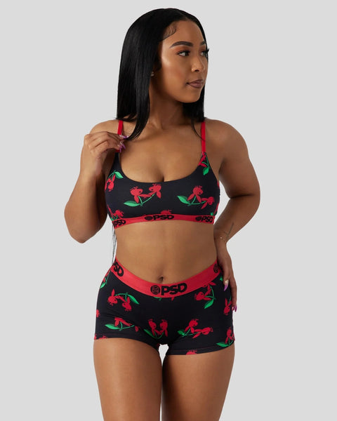 Black modal bralette and shorts set with red cherry and green leaf print, red trim, and red straps.