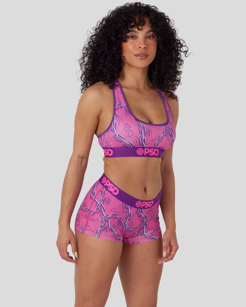 Woman wearing pink and purple patterned sports bra and matching shorts with PSD branding.