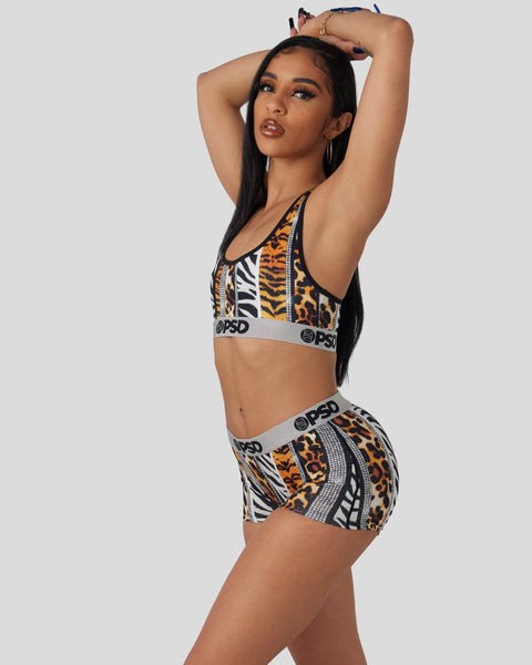 Woman wearing animal print sports bra and shorts set with zebra and leopard patterns and branded elastic bands.