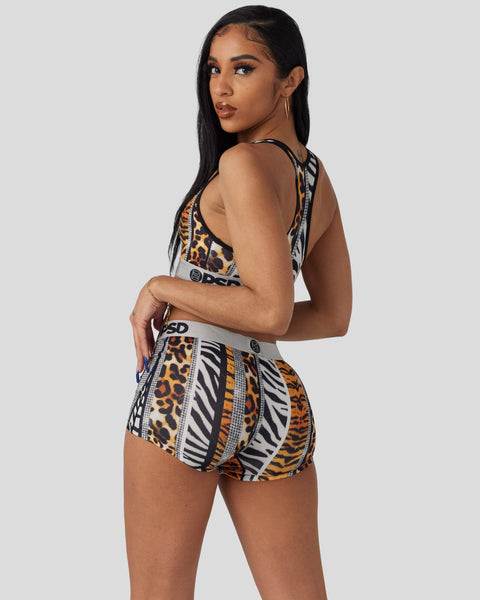 Woman wearing a two-piece set with mixed leopard and zebra stripe patterns in black, white, and orange.