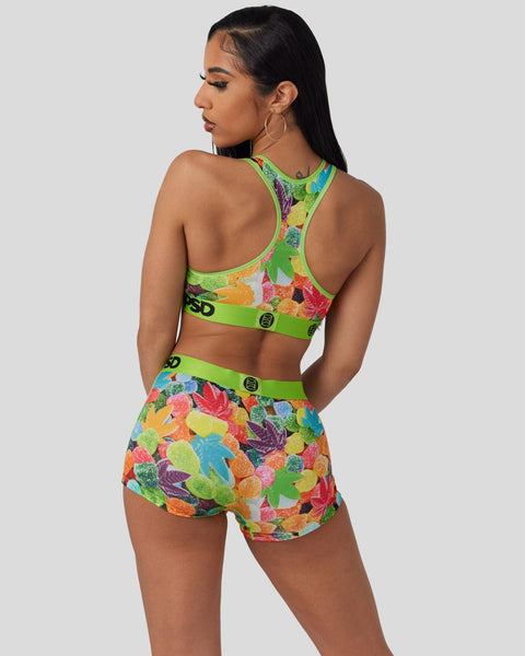 Woman wearing a two-piece athletic set with colorful fruit print and neon green trim, shown from behind.