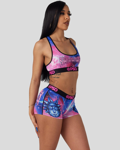 Woman wearing pink and blue sports bra and shorts set with Rick and Morty graphic and PSD branding.
