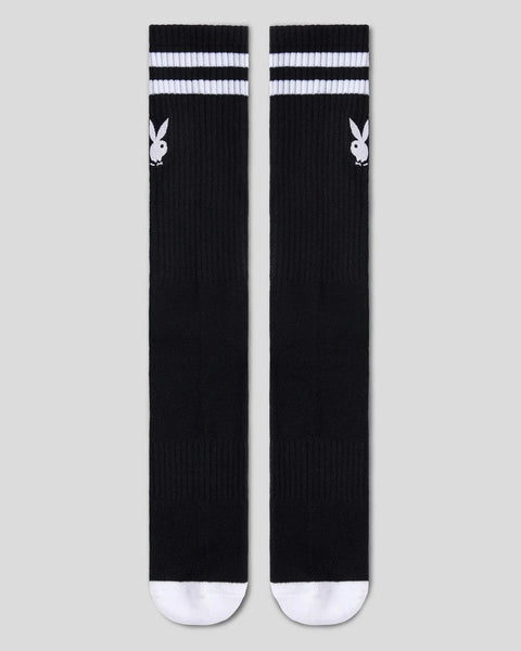 Two black crew socks with white Playboy bunny logos, white striped cuffs, and white toe and heel sections.