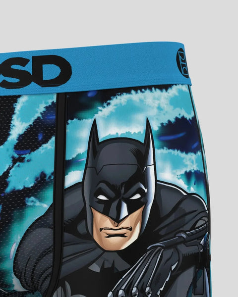 Batman character with black mask and cowl on blue tie-dye background with turquoise and navy swirl pattern.