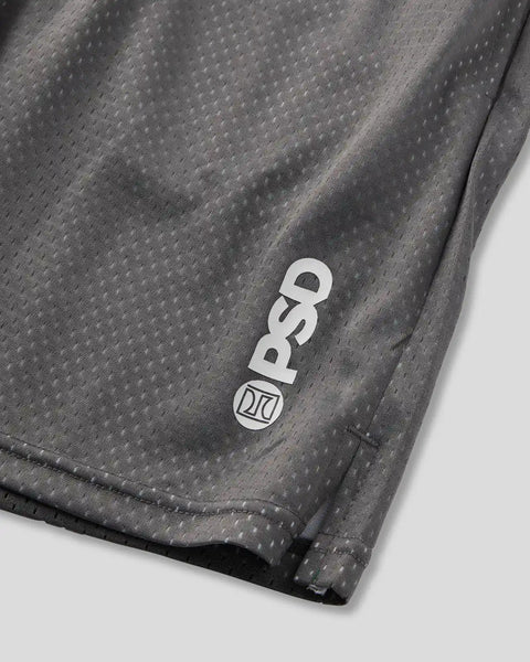 Charcoal gray athletic short with textured fabric and white logo badge on thigh.