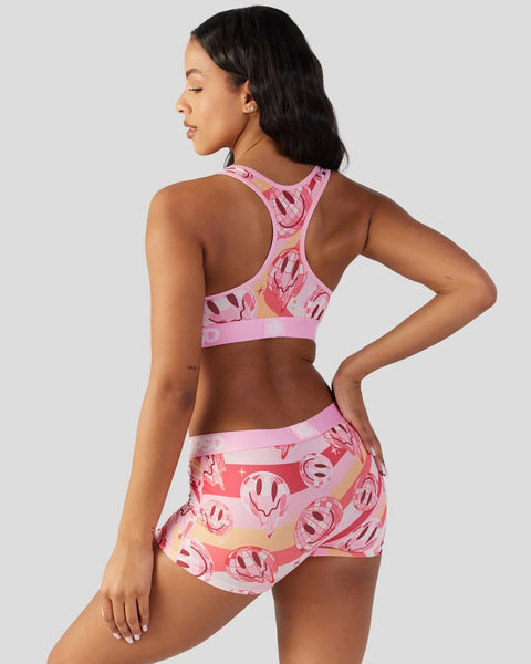Pink sports bra and shorts set with smiley face print in varying shades of pink.