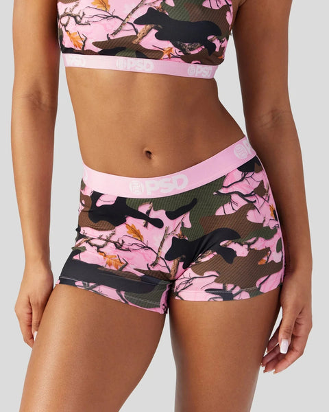 Two-piece athletic set with pink camo print featuring black silhouettes, cropped top and shorts with pink elastic waistbands.