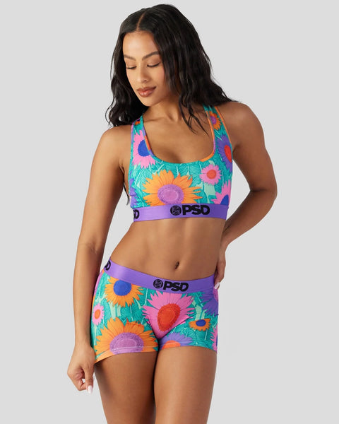 Colorful floral print sports bra and shorts set with turquoise, pink, orange, and purple sunflower design and purple branded 